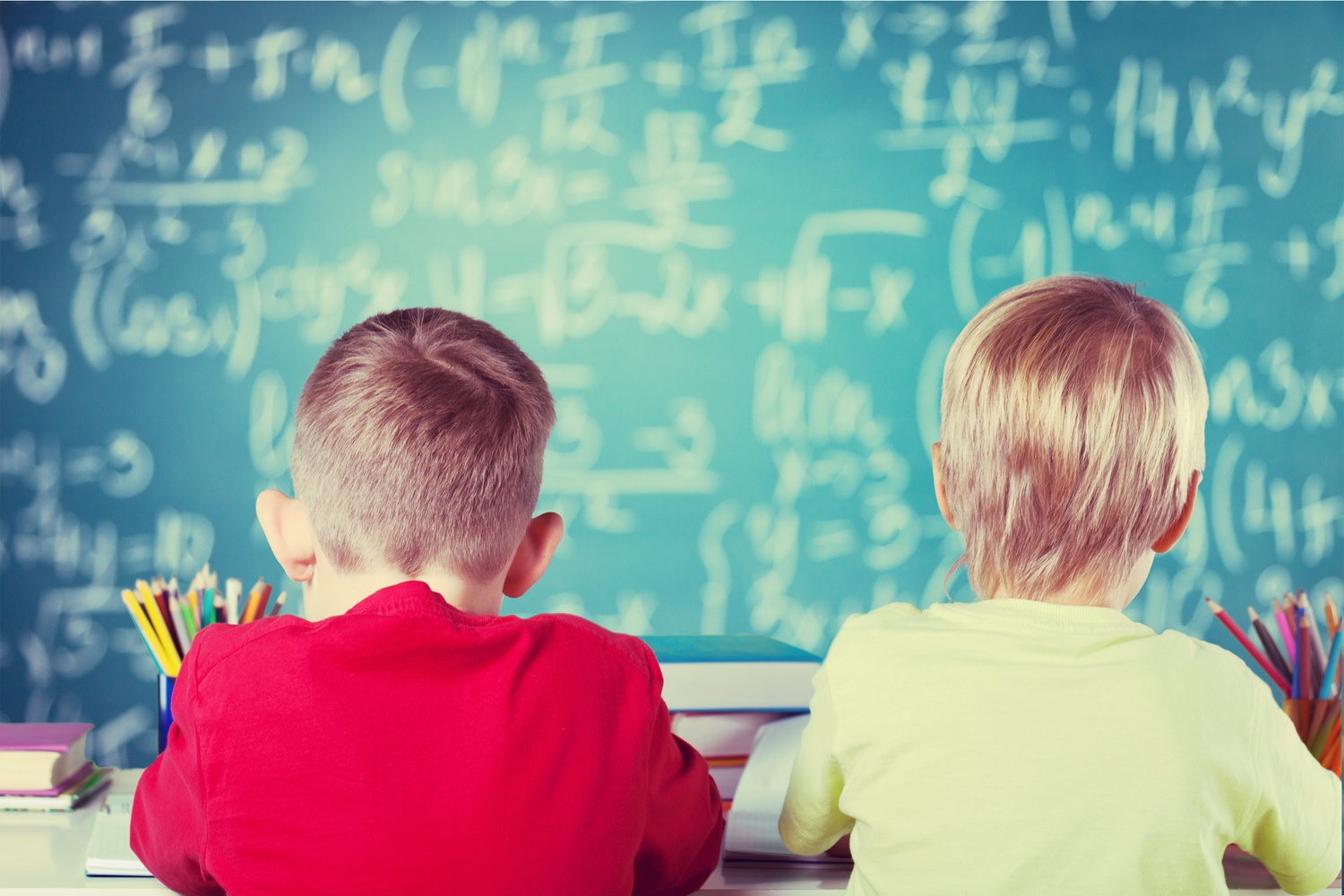 Schulkinder vor Tafel mit mathematischen Formeln